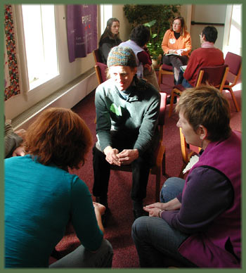 several groups of individuals, seated in a circles, engaged in connecting conversation