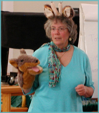 Peggy demonstrates the use of giraffe ears and jackal puppet during a Level 1 training